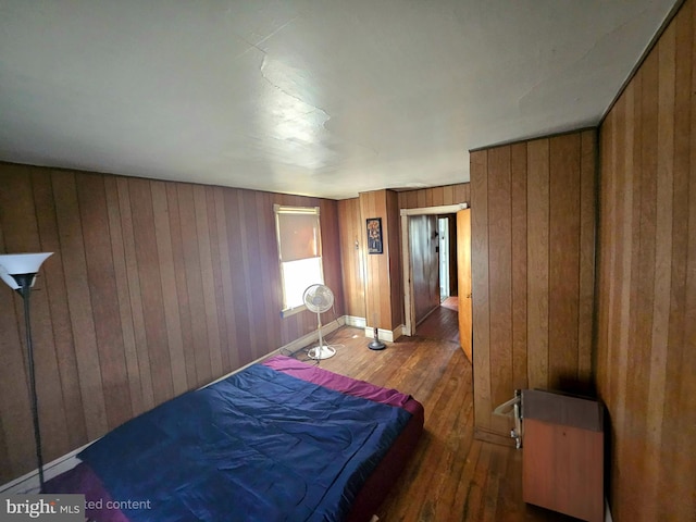 bedroom featuring wood walls and dark hardwood / wood-style flooring