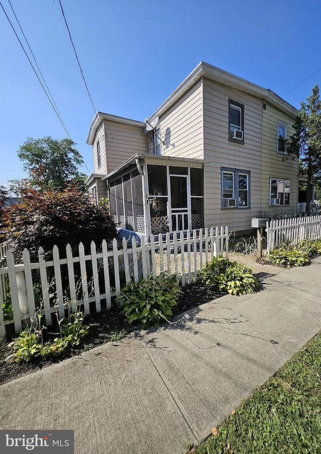 view of property exterior with a sunroom