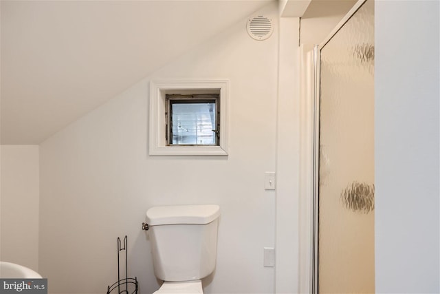 bathroom with a shower with door, lofted ceiling, and toilet