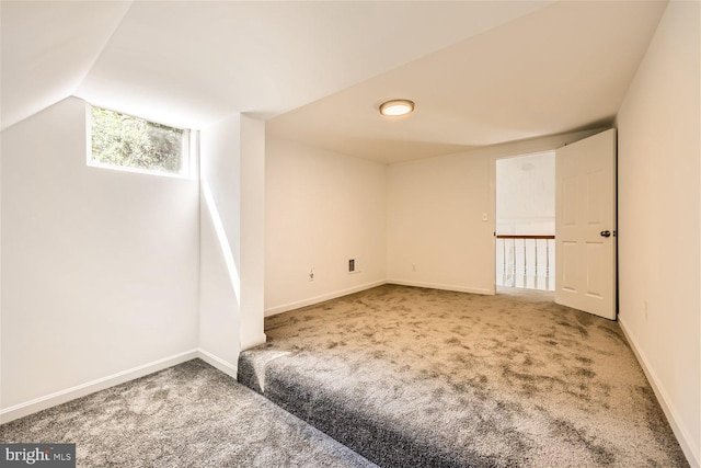 carpeted spare room with lofted ceiling