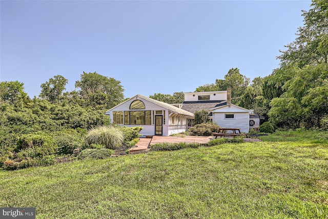 view of front of home with a sunroom and a front yard