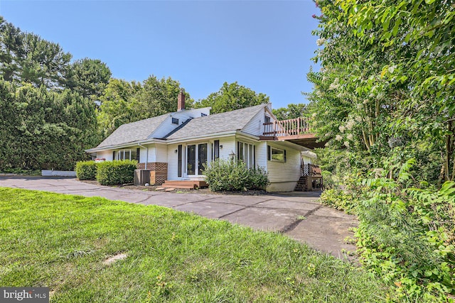 view of front of home featuring a front yard and a wooden deck