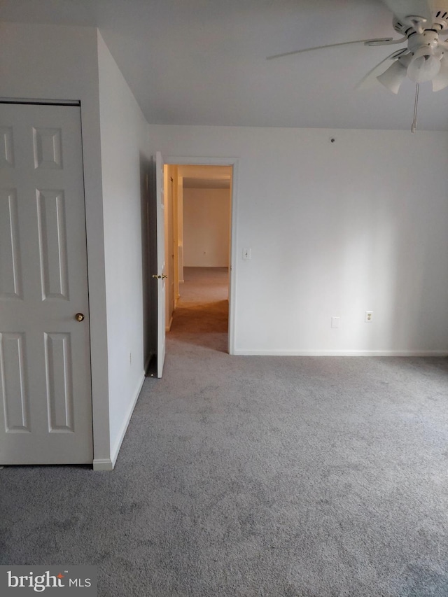 carpeted spare room featuring ceiling fan