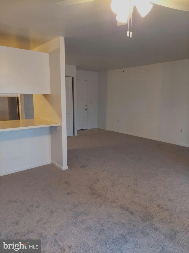 unfurnished living room featuring light carpet and ceiling fan