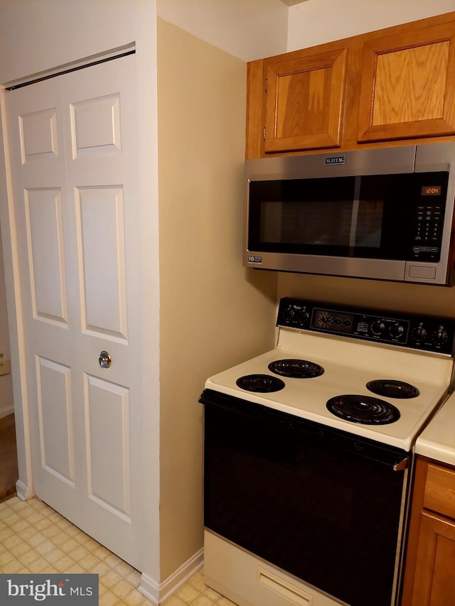 kitchen featuring stainless steel microwave and white electric stove