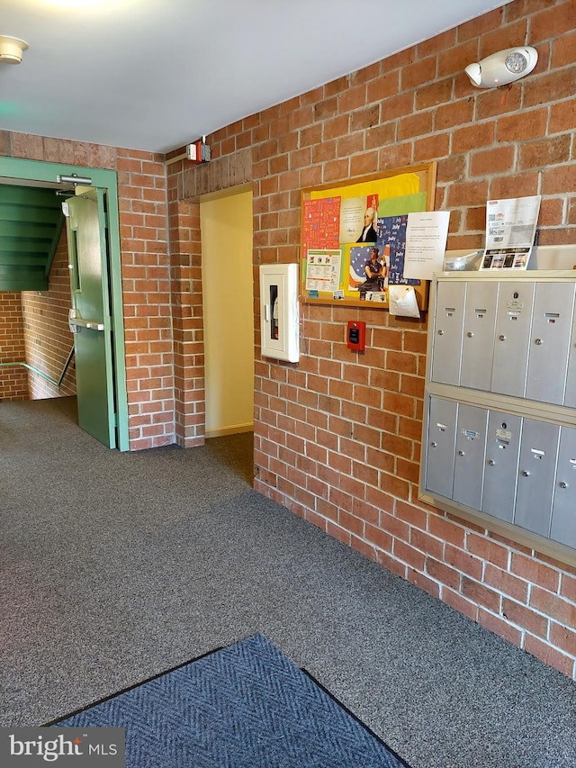 interior space featuring carpet flooring, mail boxes, and brick wall