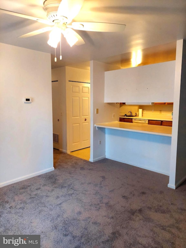 kitchen featuring ceiling fan, carpet floors, sink, and kitchen peninsula