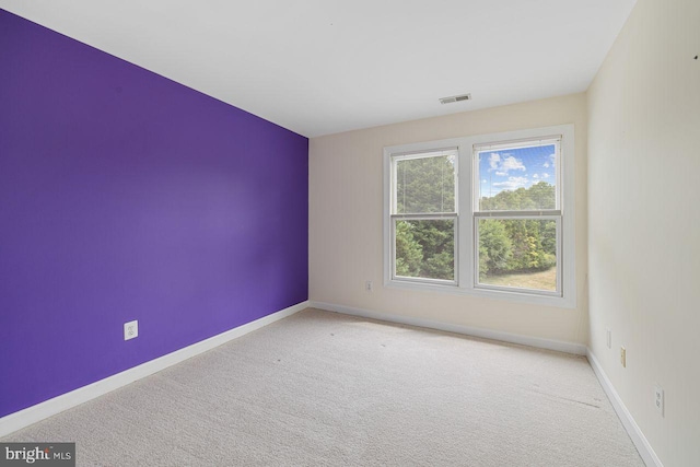 unfurnished room featuring light carpet