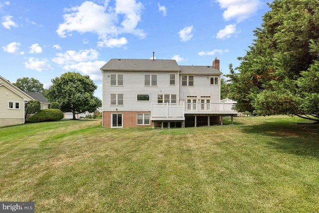 rear view of property with a wooden deck and a yard