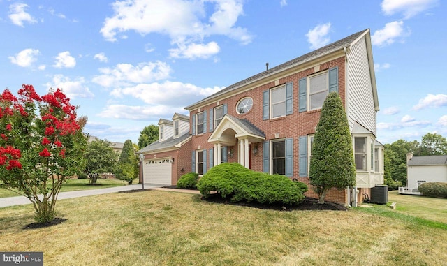 view of front of house with cooling unit, a garage, and a front lawn