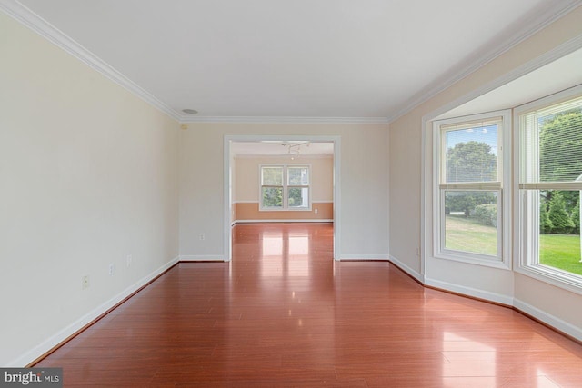 spare room with an inviting chandelier, hardwood / wood-style floors, and ornamental molding