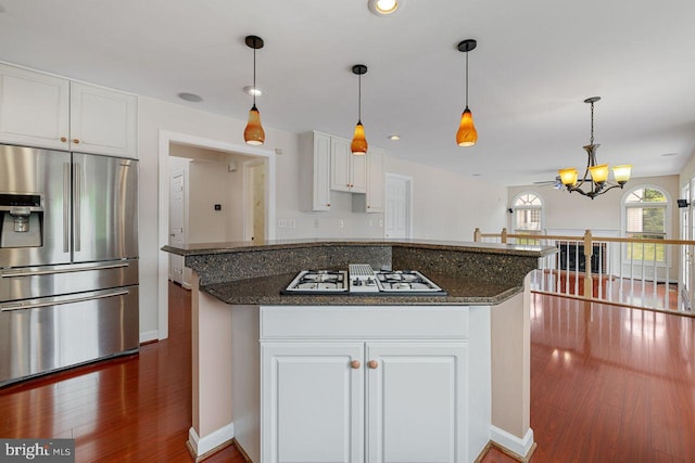 kitchen featuring white cabinetry, dark stone counters, white gas cooktop, and stainless steel fridge with ice dispenser