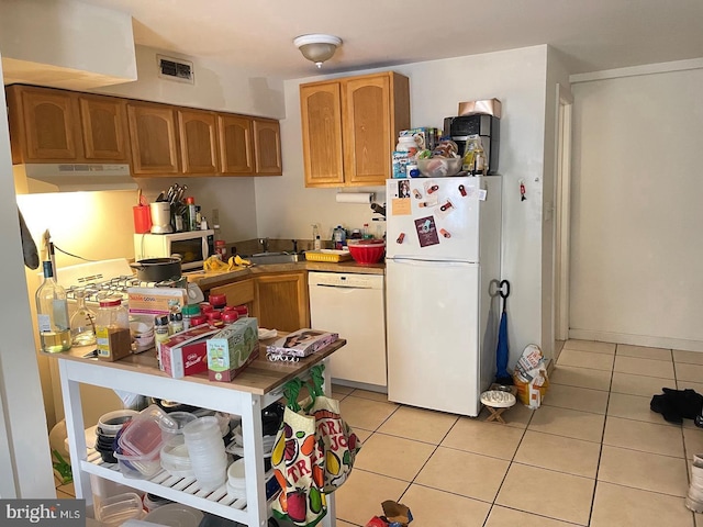 kitchen with white appliances and light tile patterned flooring