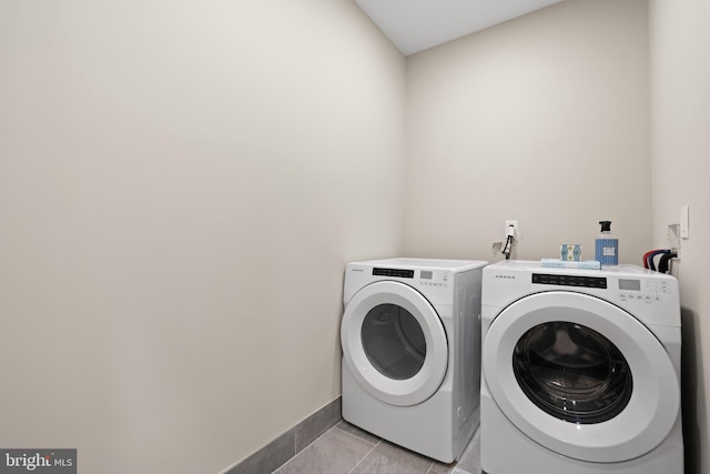 clothes washing area featuring washing machine and dryer and light tile patterned flooring