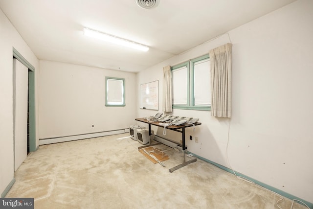 miscellaneous room featuring a baseboard heating unit and light carpet