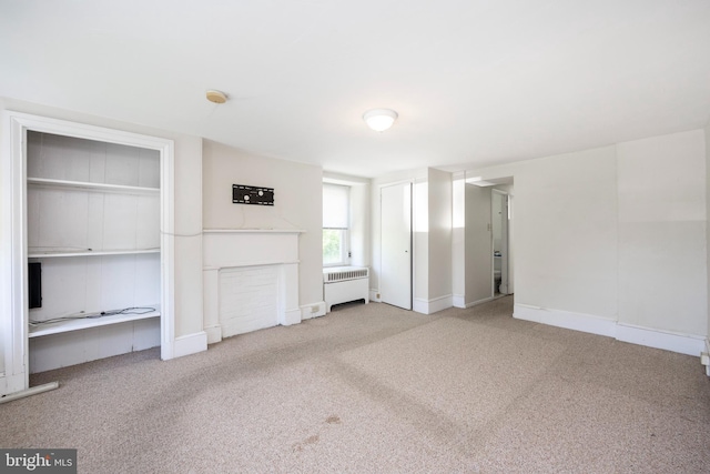 unfurnished bedroom featuring carpet floors and radiator