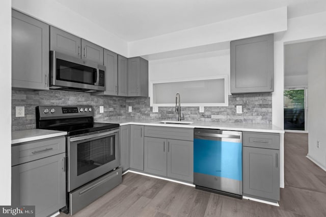 kitchen with gray cabinets, sink, and appliances with stainless steel finishes