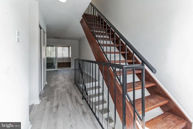 staircase with hardwood / wood-style flooring