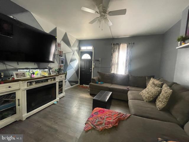 living room featuring dark hardwood / wood-style flooring and ceiling fan