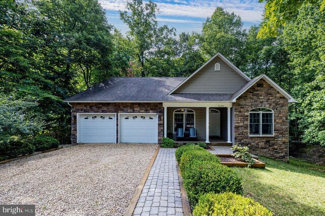 view of front of home featuring a garage, a porch, and a front yard