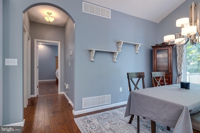 dining room featuring wood-type flooring and vaulted ceiling