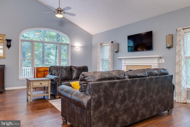 living room featuring plenty of natural light, vaulted ceiling, dark hardwood / wood-style flooring, and ceiling fan