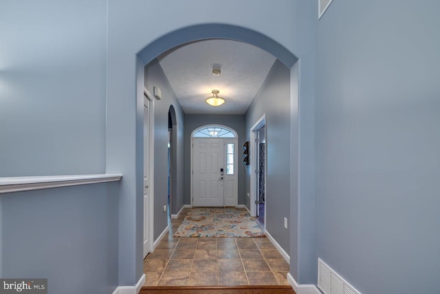 doorway featuring tile patterned flooring and a textured ceiling