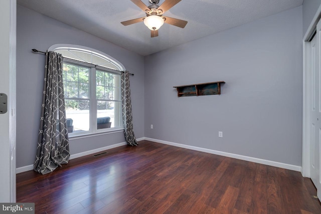 empty room with lofted ceiling, wood-type flooring, a textured ceiling, and ceiling fan