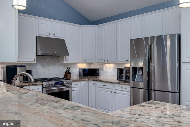 kitchen with white cabinets, light stone counters, decorative backsplash, and appliances with stainless steel finishes