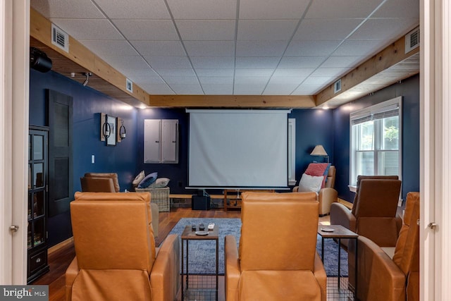 cinema room featuring hardwood / wood-style flooring and a paneled ceiling