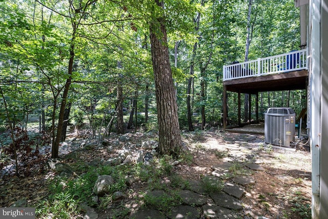 view of yard with a deck and central AC