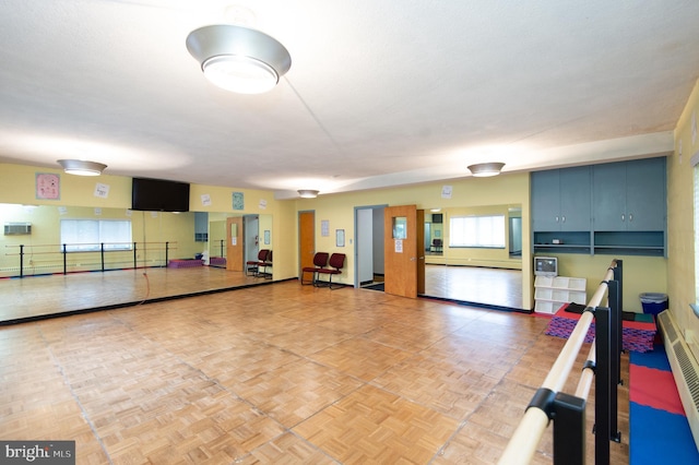 exercise room featuring parquet flooring