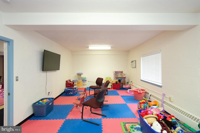 rec room with an AC wall unit and a baseboard heating unit