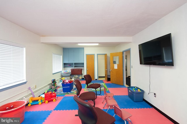 game room with beam ceiling and a textured ceiling