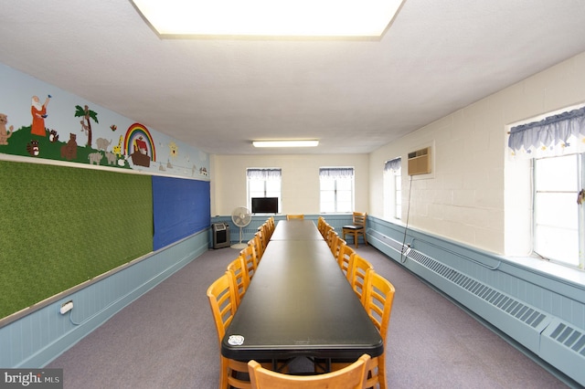 rec room featuring a wall mounted air conditioner, a healthy amount of sunlight, carpet, and a baseboard heating unit