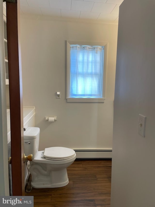 bathroom featuring hardwood / wood-style flooring, toilet, and a baseboard radiator