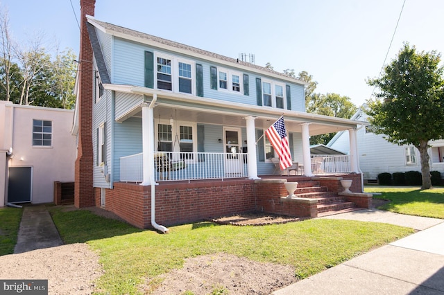 view of front of house with covered porch and a front lawn