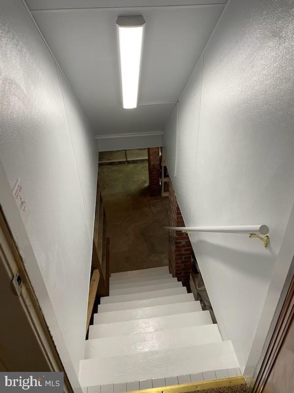 staircase featuring concrete floors