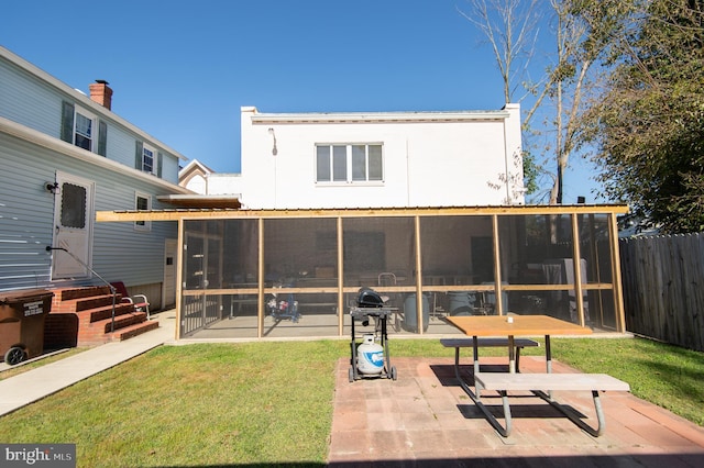 back of house featuring a patio area, a sunroom, and a yard