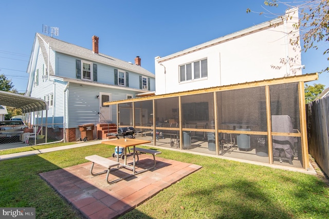 back of property with a lawn and a sunroom