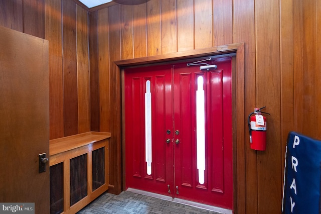 foyer entrance featuring wooden walls