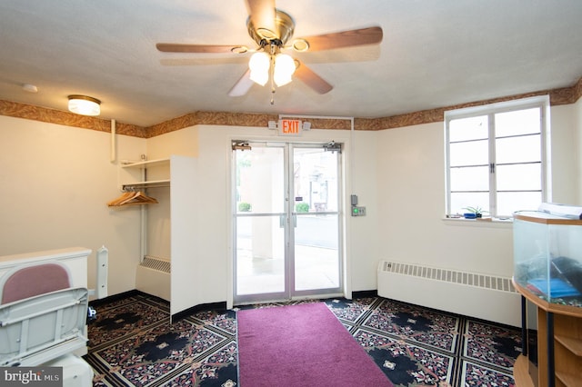 interior space featuring radiator heating unit, a textured ceiling, and ceiling fan