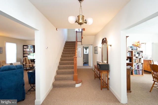 staircase featuring carpet flooring and a notable chandelier