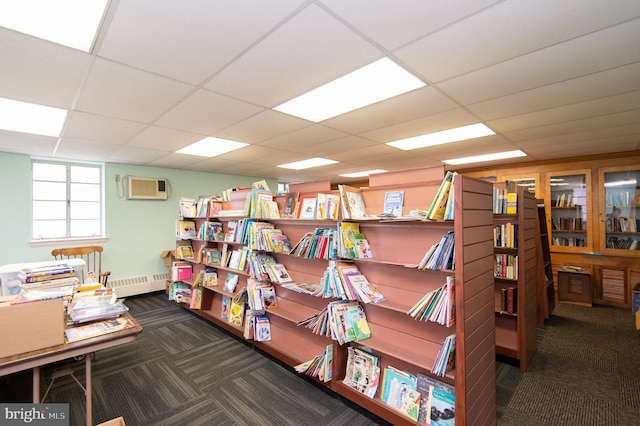 carpeted office with a wall unit AC and a drop ceiling