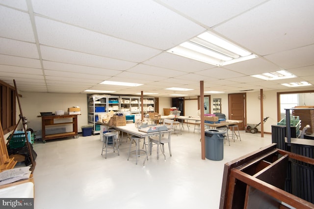 interior space with a paneled ceiling and concrete flooring