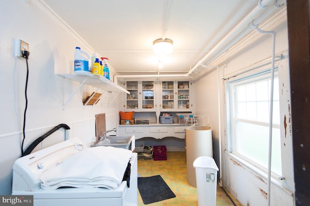 laundry area featuring crown molding, sink, and washer / dryer