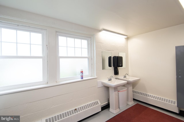 bathroom with a baseboard heating unit, radiator heating unit, and double sink