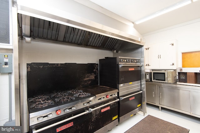 kitchen featuring oven, white cabinetry, and extractor fan