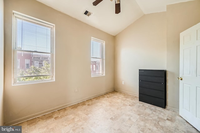 spare room with ceiling fan, vaulted ceiling, and light tile patterned floors