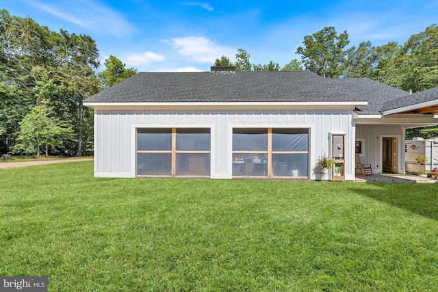 rear view of house featuring a lawn